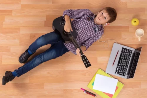 Dreng lytter til musik på gulv