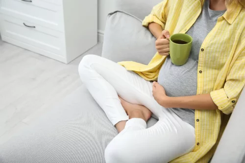 Gravid kvinde drikker kaffe