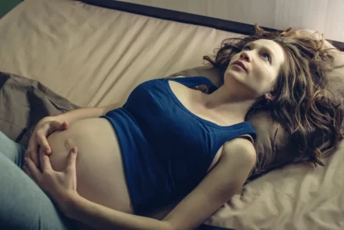 Kvinde i seng prøver at få hvile under graviditeten