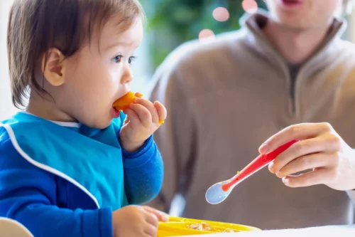 Lille barn spiser selv som eksempel på at lære børn at tygge