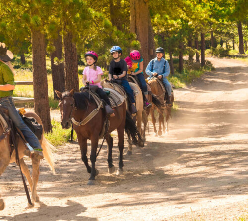 Børn rider som eksempel på aktiviteter til sommerlejr