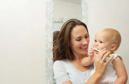En baby får børstet tænder