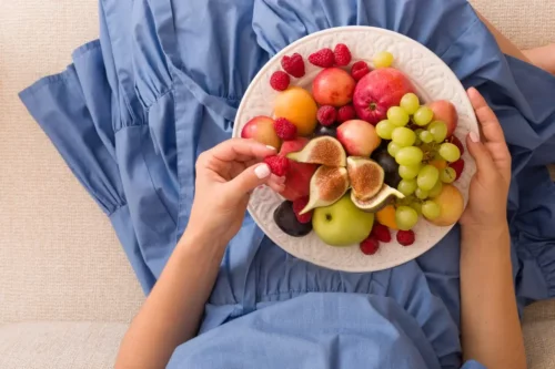 Kvinde spiser en masse forskelligt frugt