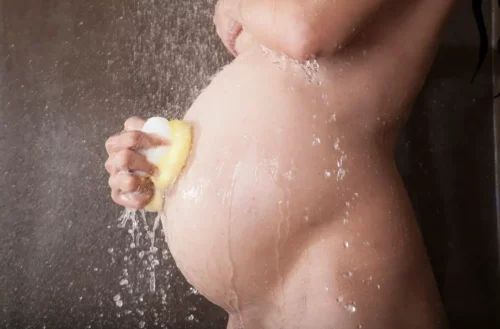 Gravid kvinde tager et brusebad