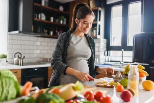 Gravid kvinde laver mad