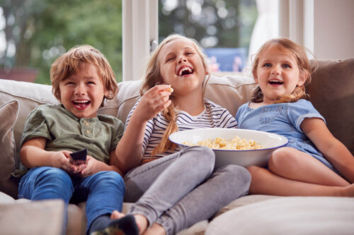 Børn ser fjernsyn og spiser popcorn