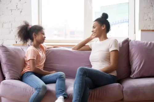 Mor og datter taler sammen i sofa