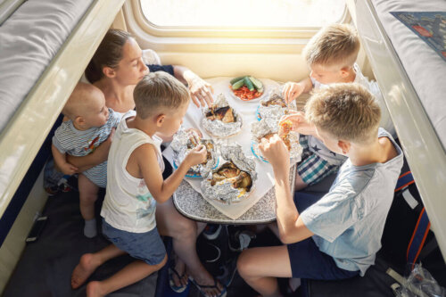 Familie spiser i en autocamper som eksempel på at rejse med en stor familie