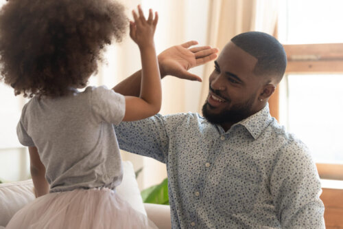 Far giver barn high five som en del af at lære om værdien af engagement