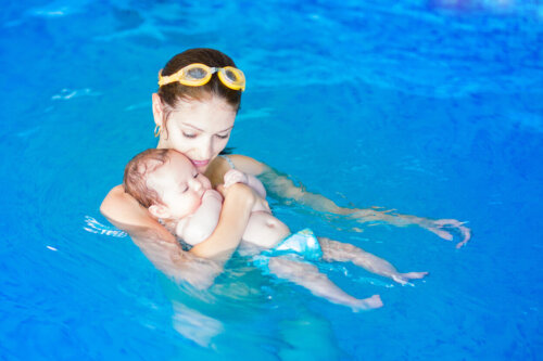 Mor og baby laver svømmeøvelser