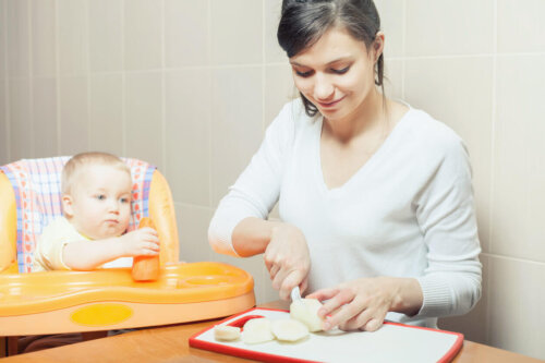 En mor laver mad med sin baby