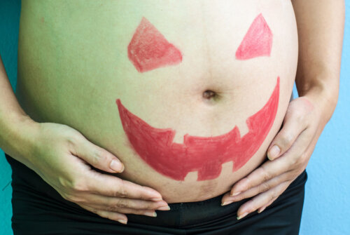 Gravid mave med skræmmende ansigt malet på som eksempel på kostumer til gravide