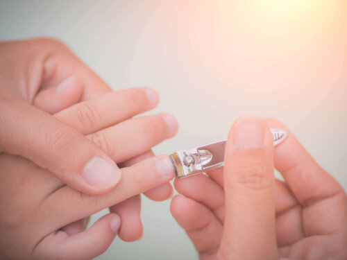 En person er ved at klippe et barns negle