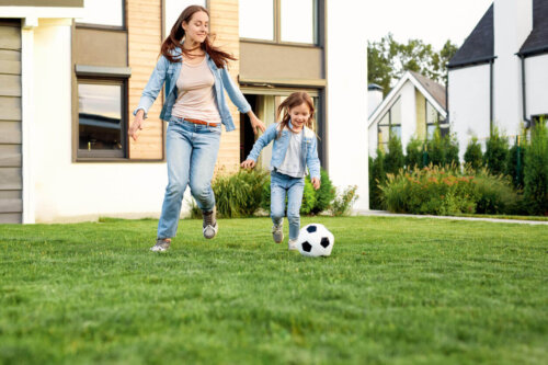 Mor og barn spiller fodbold udenfor