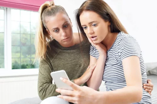 Mor og teenager med telefon oplever risiciene ved sociale netværk