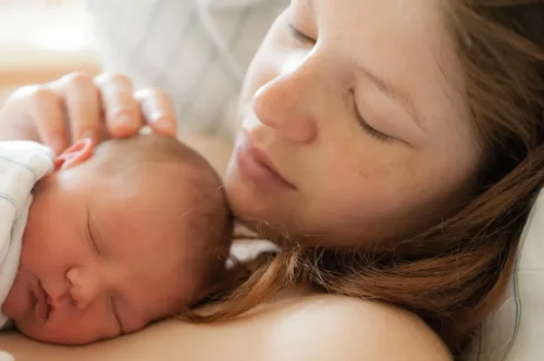 Nyfødt mor med baby nyder hud-mod-hud-kontakt
