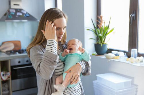 Træt mor går med en grædende baby