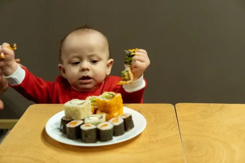 Baby rækker ud efter sushi