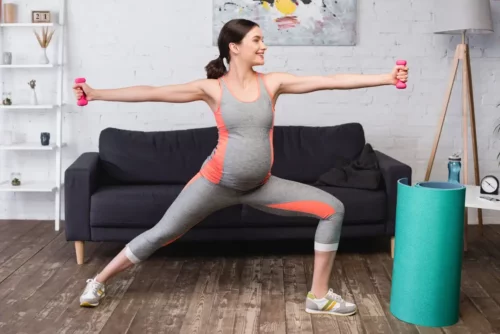 Kvinde motionerer i sportstøj til gravide
