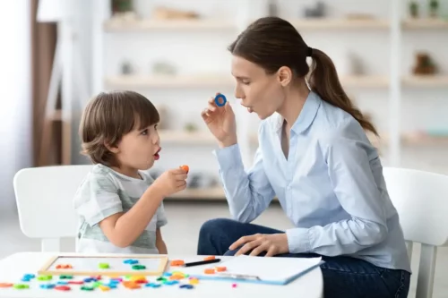 Kvinde og dreng viser, hvordan man kan arbejde på at forbedre et barns tale