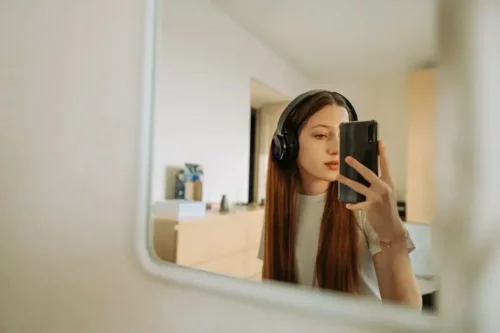 Ung kvinde tager selfie i spejl