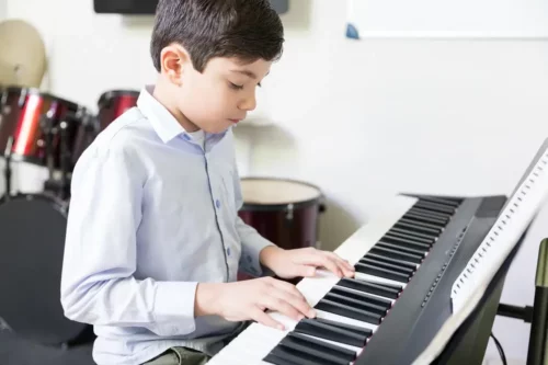 Dreng spiller keyboard og repræsenterer drengenavne inspireret af sange