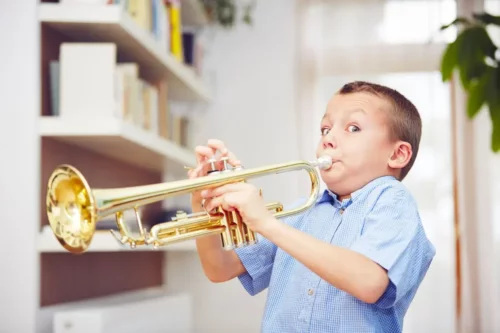 Dreng spiller på trompet