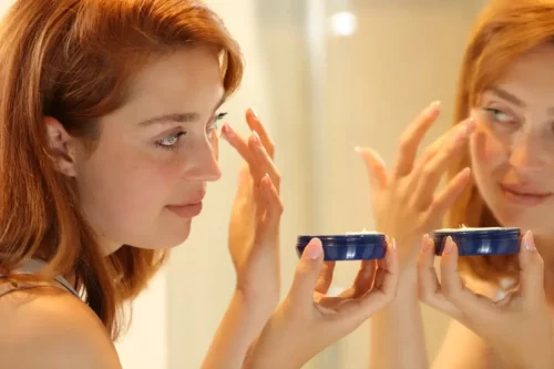 Kvinde påfører ansigtscreme for at slippe af med træt hud