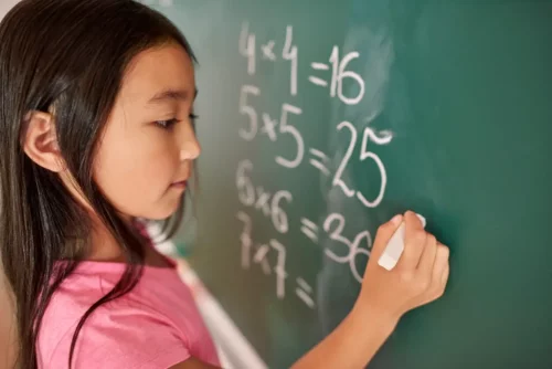 Barn udregner regnestykker på tavle