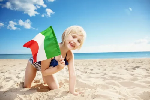 Pige med italiensk flag på en strand