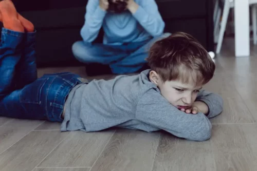 Sur dreng på gulv repræsenterer humørsvingninger hos små børn