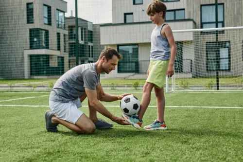 Far og søn spiller fodbold