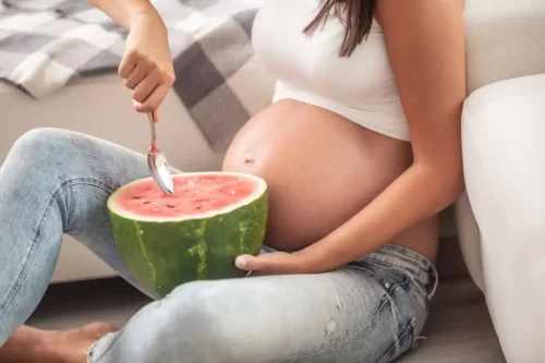 Kvinde spiser vandmelon under graviditet
