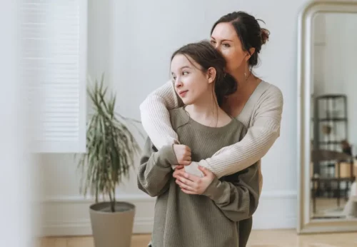 Mor krammer datter og repræsenterer vigtigheden af at acceptere børn, som de er