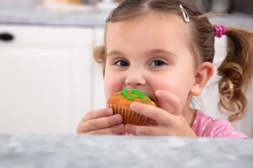 En pige spiser en kage