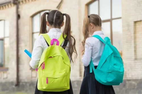 Piger med tunge skoletasker som eksempel på årsager til rygsmerter hos børn og unge