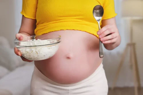 Gravid kvinde med en skål med hytteost