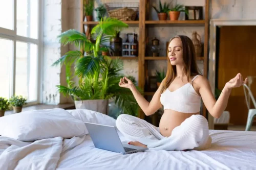 Gravid kvinde mediterer i seng