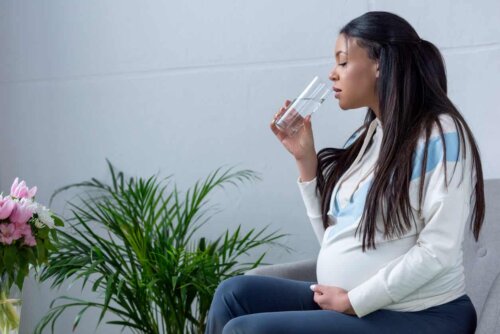 Gravid kvinde drikker vand